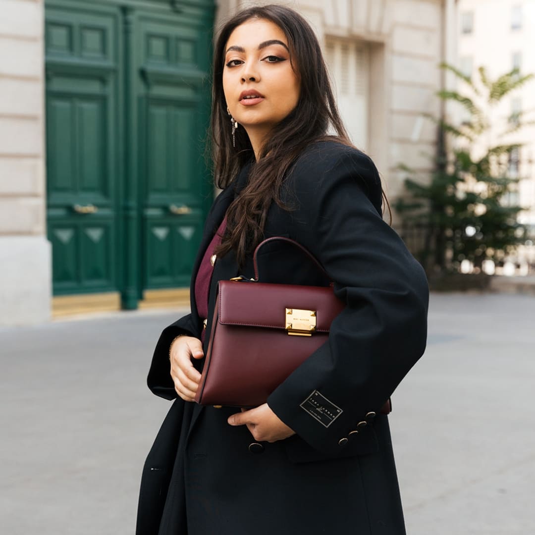 Découvrez le sac Mélyssa co-créé avec mélyssa, un sac à main bordeaux aux bijoux dorés. 